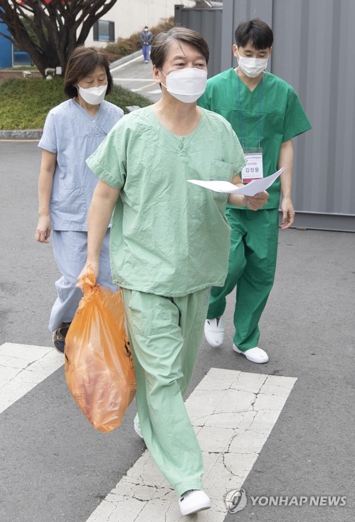 의료 봉사 이어가는 안철수 대표'의사 부부' 안철수 국민의당 대표(가운데)와 부인 김미경 교수가 지난 13일 오전 대구시 신종 코로나바이러스 감염증(코로나19) 지역거점병원인 계명대학교 대구동산병원에서 진료 자원봉사를 하기 위해 이동하고 있다.[연합뉴스 자료사진]