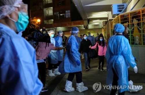 코로나19 확진자가 발생한 아파트에서 주민들을 대피시키는 홍콩 정부 요원들(홍콩=로이터 연합뉴스)