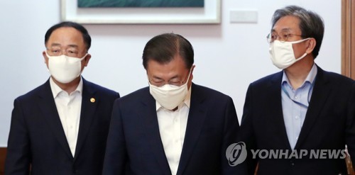 비상경제회의 입장하는 문 대통령(서울=연합뉴스) 한상균 기자 = 문재인 대통령이 30일 청와대에서 열린 신종 코로나바이러스 감염증(코로나19) 관련 제3차 비상경제회의에 입장하고 있다. 오른쪽부터 노영민 비서실장, 문 대통령, 홍남기 경제부총리. 2020.3.30 xyz@yna.co.kr