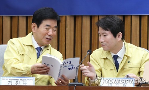 3월 23일 국회에서 열린 더불어민주당 코로나19국난극복위원회에서 이인영 총괄본부장(오른쪽)과 김진표 비상경제대책본부장이 총선공약 정책집을 살펴보고 있다. [연합뉴스 자료사진]