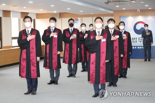 코로나19가 바꾼 신임검사 임관식 풍경(과천=연합뉴스) 임화영 기자 = 1일 오후 경기도 정부과천청사 법무부에서 열린 '신임검사 임관식'에서 마스크를 쓴 신임 검사들이 국기에 경례하고 있다. 2020.4.1 hwayoung7@yna.co.kr
