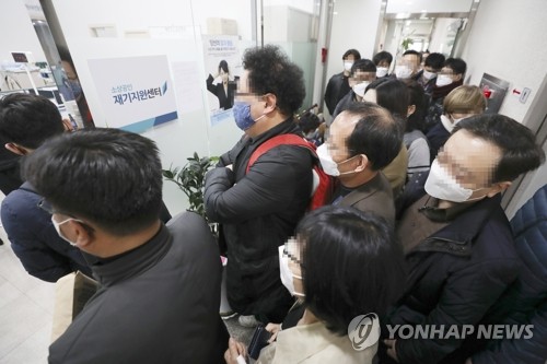 신종 코로나바이러스 감염증(코로나19) 사태에 따른 소상공인 긴급 대출 접수가 시작된 2020년 3월 25일 오전 서울 종로구 소상공인 진흥공단 서울중부센터에서 소상공인들이 번호표를 받기 위해 줄을 서 있다. [연합뉴스 자료사진]