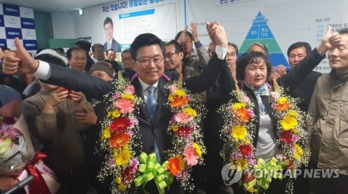 횡성군수 보궐선거 장신상 후보 환호(횡성=연합뉴스) 김영인 기자 = 횡성군수 보궐선거에서 당선이 확실시되는 민주당 장신상 후보가 15일 부인과 손을 맞잡고 기뻐하고 있다. 2020.4.15 kimyi@yna.co.kr