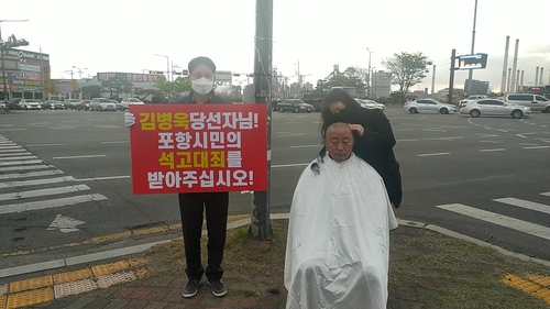 삭발하는 경북도의원(포항=연합뉴스) 17일 경북 포항시 남구 형산교차로에서 더불어민주당 소속 이재도 도의원이 삭발하고 있다.
    이 도의원은 삭발 후 엎드려 절을 하는 이른바 '석고대죄' 시위를 했다.
    그는 "이번 총선에서 승리한 미래통합당 김병욱 당선인이 소셜미디어에 '제가 당선되다 치고, 저의 의혹이 아무 문제 없이 그냥 넘어간다면 저를 비방한 분들은 형산로터리에서 포항시민에게 석고대죄해야 한다'란 글을 남겨 석고대죄했다"고 밝혔다. 2020.4.17 [독자 제공. 재판매 및 DB 금지]