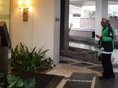 아파트 현관 앞에 음식 배달온 고젝 오토바이 기사[자카르타=연합뉴스]