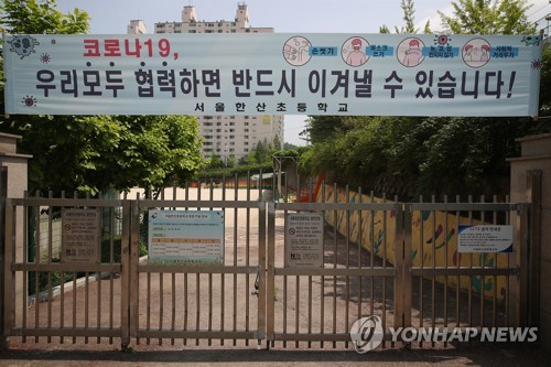 '우리 모두 협력하면'(서울=연합뉴스) 서명곤 기자 = 4일 서울 시내 한 초등학교 정문에 '우리모두 협력하면 반드시 이겨낼 수 있습니다'라고 적힌 현수막이 설치돼 있다. 교육부는 이날 오후 신종 코로나바이러스 감염증(코로나19) 여파로 두 달 넘게 미루고 있는 초·중·고등학교 등교 수업을 언제 어떻게 시작할지 발표한다.  2020.5.4 seephoto@yna.co.kr