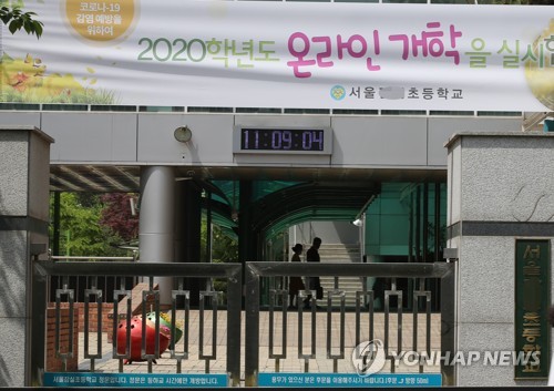 '온라인에서 오프라인으로'(서울=연합뉴스) 서명곤 기자 = 4일 서울 시내 한 초등학교 정문에 '온라인 개학'을 알리는 현수막이 설치돼 있다.  교육부는 이날 오후 신종 코로나바이러스 감염증(코로나19) 여파로 두 달 넘게 미루고 있는 초·중·고등학교 등교 수업을 언제 어떻게 시작할지 발표한다.  2020.5.4 seephoto@yna.co.kr