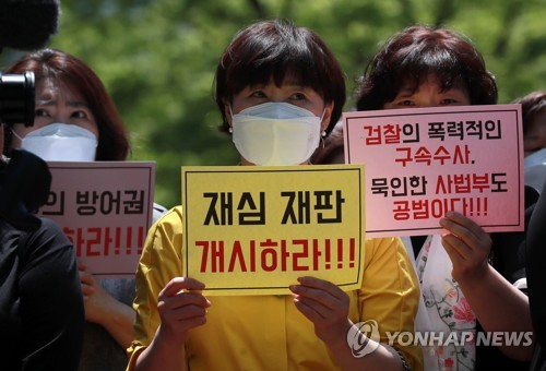 "정당방위 인정하라"(부산=연합뉴스) 손형주 기자 = 6일 오후 부산 연제구 부산지방법원에서 열린 성폭력 피해자 정당방위 인정을 위한 재심 청구 기자회견에서 참가자들이 손팻말을 들고 있다. 2020.5.6 handbrother@yna.co.kr