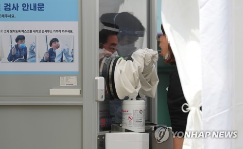 선별 진료소 찾은 시민(서울=연합뉴스) 김도훈 기자 = 이태원 클럽발 신종 코로나바이러스 감염증(코로나19) 집단감염이 급증하고 있는 11일 오후 서울 중구 국립중앙의료원 선별진료소를 찾은 시민이 검체 채취를 하고 있다. superdoo82@yna.co.kr