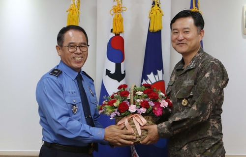 (동해=연합뉴스) 김영모 동해지방해양경찰청장이 18일 최성목 해군 1함대사령관에게 꽃바구니를 전달하고 있다. 2020.5.18 [동해 해경청 제공·재판매 및 DB 금지]