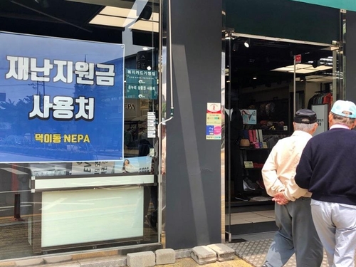 "재난지원금 사용 가능"    (고양=연합뉴스) 권숙희 기자 = 18일 오후 경기 고양시 일산서구 덕이동 로데오거리의 한 등산용품 매장에 정부 재난지원금 사용처임을 알리는 안내문이 부착돼 있다. 2020.5.18 suki@yna.co.kr
