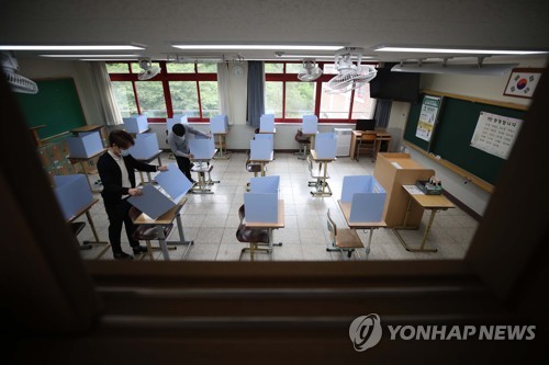'거리두고 가림막 세우고'(대구=연합뉴스) 김현태 기자 = 고등학교 3학년 학생들의 등교를 하루 앞둔 19일 대구시 수성구 정화여자고등학교 3학년 교실에서 담임 선생님 등이 신종 코로나바이러스 감염증(코로나19) 확산방지를 위해 교실에서 급식할 때만 책상마다 설치될 가림막을 살펴보고 있다. 2020.5.19 mtkht@yna.co.kr