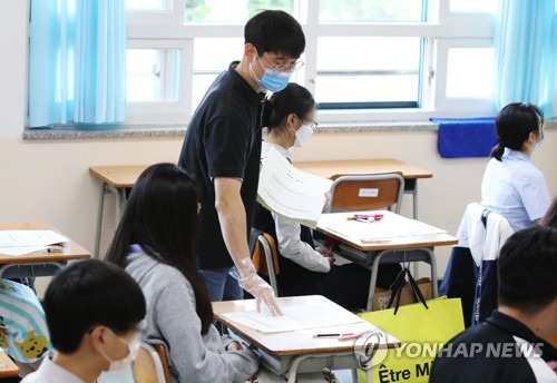 장갑 끼고 시험지 배부(수원=연합뉴스) 홍기원 기자 = 고교 3학년생을 대상으로 한 전국연합학력평가가 실시된 21일 오전 경기도 수원시 장안구 조원고등학교에서 교사가 장갑을 끼고 시험지를 나눠주고 있다. 2020.5.21 xanadu@yna.co.kr