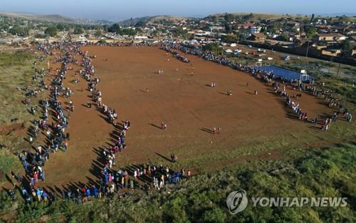 프리토리아 무허가촌 주민들이 20일 식량 배급을 받으러 길게 줄 선 모습[AP=연합뉴스]