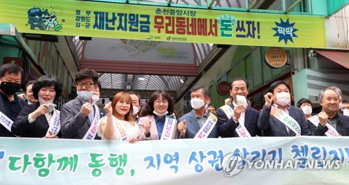 재난지원금 소비로 지역경제 살려요(춘천=연합뉴스) 양지웅 기자 = 25일 강원 춘천시 중앙시장에서 열린 '다 함께 동행, 지역경제 살리기 챌린지! 긴급재난지원금 쓰리 GO(돕고·살리고·나누고) 캠페인'에서 최문순 강원도지사와 한금석 도의회 의장을 비롯한 참석자들이 기념촬영을 하고 있다. 2020.5.25 yangdoo@yna.co.kr