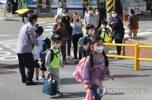 교문 밖에서 지켜보는 학부모(부산=연합뉴스) 차근호 기자 = 코로나19 사태로 미뤄진 초등학교 등교수업이 재개된 27일 오전 부산 동구 수정초등학교에서 1∼2학년 학생들이 등교하는 모습을 학부모가 지켜보고 있다. 2020.5.27 ready@yna.co.kr