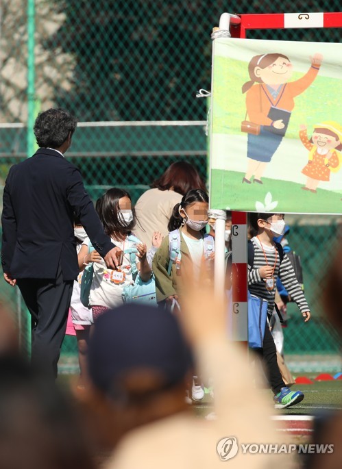'엄마 아직 있어'(서울=연합뉴스) 임헌정 기자 = 초등학교 1∼2학년의 등교 개학이 시작된 27일 오전 서울의 한 초등학교에서 한 학부모가 운동장에 있는 아이를 보며 손을 흔들고 있다. 2020.5.27 kane@yna.co.kr
