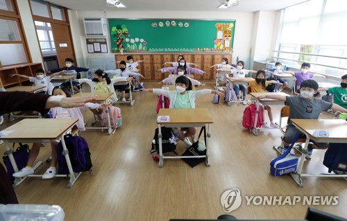 '이만큼 떨어져서 생활해요'(대전=연합뉴스) 김준범 기자 = 초등학교 1~2학년과 유치원생 등교 수업이 시작된 27일 오전 대전시 중구 대전문화초등학교에서 학생들이 주의사항을 듣고 있다. 2020.5.27 psykims@yna.co.kr