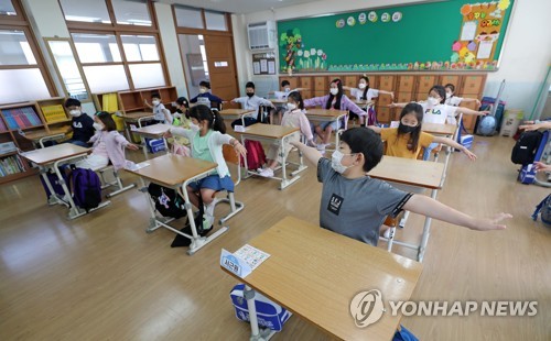 '이만큼 떨어져서 생활해요'(대전=연합뉴스) 김준범 기자 = 초등학교 1~2학년과 유치원생 등교 수업이 시작된 27일 오전 대전시 중구 대전문화초등학교에서 학생들이 주의사항을 듣고 있다. 2020.5.27 psykims@yna.co.kr