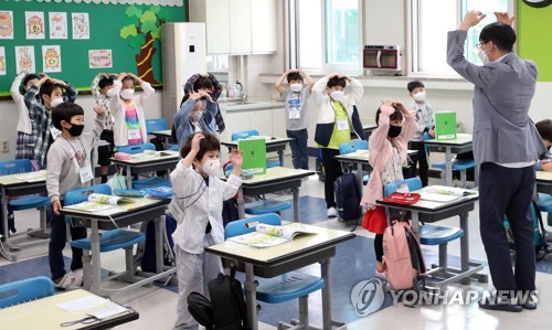 우리 서로 사랑해요(춘천=연합뉴스) 양지웅 기자 = 전국 유치원생과 초등학교 1∼2학년생, 중학교 3학년생, 고등학교 2학년생의 등교 수업이 재개된 27일 오전 강원 춘천시 금병초등학교에서 1학년생들이 교사와 인사하고 있다. 2020.5.27 yangdoo@yna.co.kr