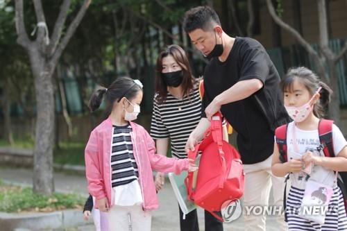 "학교 잘 다녀와"(광주=연합뉴스) 천정인 기자 = 유치원과 초등학교 1~2학년 등교 이틀째인 28일 광주 서구 치평동 계수초등학교 앞에서 초등학생이 부모의 배웅을 받으며 등교하고 있다. 2020.5.28 iny@yna.co.kr