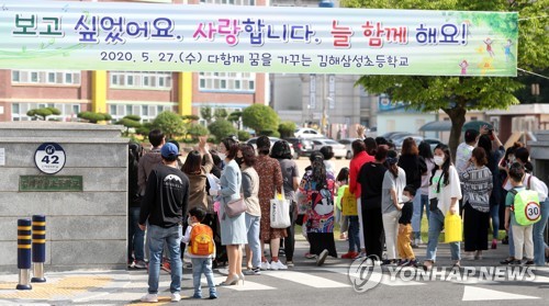 올해 첫 등굣길초등학교 저학년 등교 첫날인 5월 27일 오전 경남 김해시 김해삼성초등학교 입구에서 학부모들이 자녀 등교 모습을 바라보고 있다. 2020.5.27