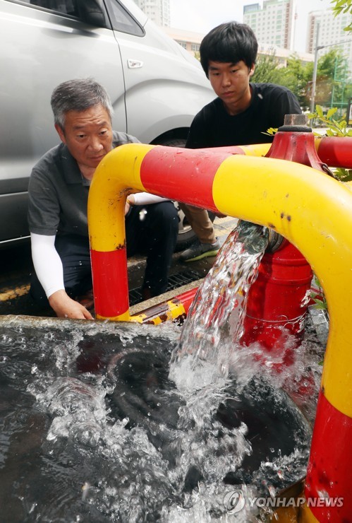 붉은 수돗물 피해지역서 소화전 수돗물 검사[연합뉴스 자료사진]