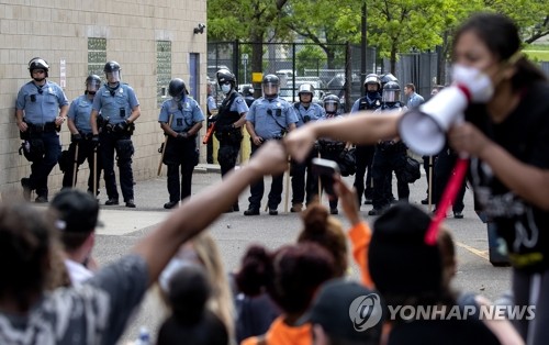 경찰과 대치하는 미네소타 흑인 사망 분노 시위대(미니애폴리스 AP=연합뉴스) 27일(현지시간) 미국 미네소타 주 미니애폴리스에서 백인 경찰의 가혹행위로 흑인 남성 조지 플로이드 숨진 것에 항의하는 시위대가 경찰과 대치하고 있다. leekm@yna.co.kr