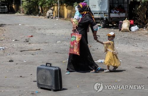 뭄바이에서 고향으로 돌아가려고 길을 나선 인도 여성 이주노동자와 자녀. [EPA=연합뉴스]