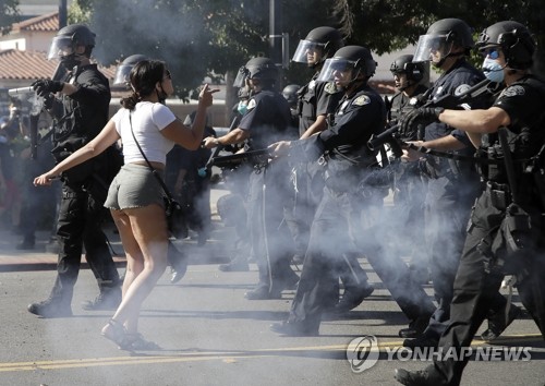 경찰에 맞서 '흑인사망' 항의하는 캘리포니아 시위대(새너제이 AP=연합뉴스) 미국 백인 경찰의 가혹 행위로 흑인 남성 조지 플로이드가 사망한 사건에 항의하는 시위가 미전역으로 확산하는 가운데 29일(현지시간) 캘리포니아주 새너제이의 한 시위 참가자가 경찰과 맞서고 있다. leekm@yna.co.kr
