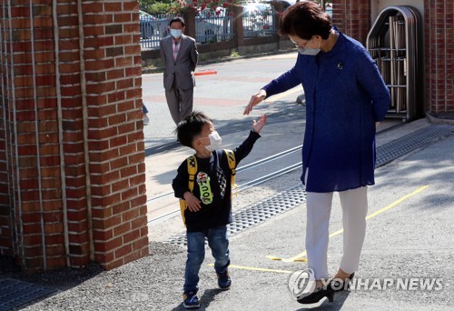 '교장 선생님, 손잡아주세요'(광주=연합뉴스) 박철홍 기자 = 코로나19 재확산세가 이어진 29일 오전 광주 북구 오치초등학교 병설 유치원에서 등교하는 한 유치원생이 손 소독을 한 교장 선생님의 손을 잡고 있다. 2020.5.29 pch80@yna.co.kr