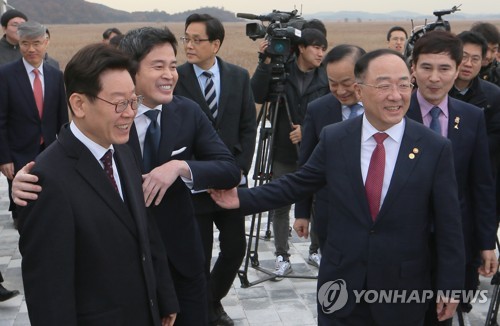 이재명 지사와 홍남기 부총리(화성=연합뉴스) 지난해 11월 21일 경기도 화성국제테마파크 예정지에서 열린 '화성국제테마파크 비전 선포식'에서 이재명 경기도지사(왼쪽부터), 정용진 신세계 부회장, 홍남기 부총리 겸 기획재정부 장관 등 참석자들이 사업 부지를 살펴보며 환하게 웃고 있다. 2019.11.21 [연합뉴스 자료사진. 재판매 및 DB 금지]