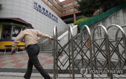 서울 돈암초, 등교수업 중지(서울=연합뉴스) 최재구 기자 = 2일 서울 성북구 돈암초등학교에서 학교보안관이 교문을 닫고 있다. 돈암초등학교의 야간 당직자가 코로나19 감염 확진 판정을 받으며 2일 학생들의 등교수업이 중지됐다. 2020.6.2 jjaeck9@yna.co.kr