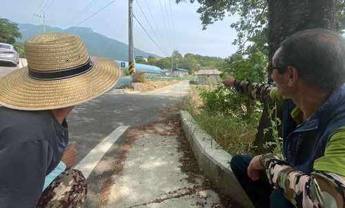 평산마을 주민(양산=연합뉴스) 김동민 기자 = 문재인 대통령 내외가 경남 양산 하북면 평산마을 한 주택을 매입했다는 소식이 전해진 5일 마을 입구에서 주민들이 문 대통령 사저 방향을 손으로 가리키며 대화하고 있다. 2020.6.5