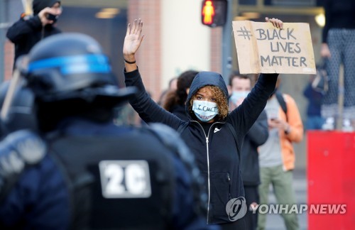 지난 4일 프랑스 릴에서 열린 시위에서 한 흑인 여성이 '흑인의 생명은 소중하다'라고 영어로 적힌 푯말을 들고 시위하고 있다. [로이터=연합뉴스 자료사진]