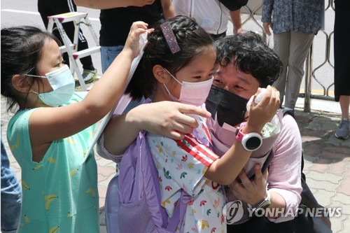 "첫 등교 축하해" 꽃다발 건네는 아빠(광주=연합뉴스) 천정인 기자 = 유치원과 초등학교 1~2학년이 첫 등교를 한 27일 광주 서구 치평초등학교에서 한 학부모가 첫 등교를 축하하는 꽃다발과 인형 선물을 자녀에게 전하고 있다. 2020.5.27 iny@yna.co.kr