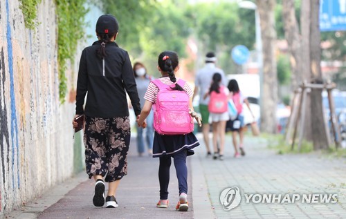 '엄마 손 잡고 가는 등굣길'(서울=연합뉴스) 김도훈 기자 = 8일 오전 1,3학년 학생을 대상으로 등교수업을 진행한 서울 용산구의 한 초등학교 앞에서 한 학생이 엄마 손을 잡고 등교하고 있다. 2020.6.8 superdoo82@yna.co.kr