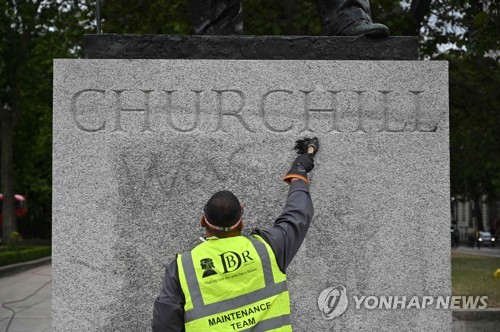 시설 보수 담당자가 처칠 동상에 적힌 낙서를 지우고 있다.[AFP=연합뉴스]