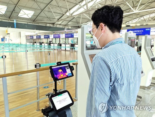 '발열체크 로봇' 서비스(서울=연합뉴스) 인천국제공항공사가 스마트 방역 서비스 확대를 위해 15일부터 인천공항 1터미널과 2터미널 3층 출국장에 로봇과 키오스크를 활용한 비대면 발열 체크 서비스를 시범 도입한다고 밝혔다.
    사진은 인천공항 1여객터미널 출국장에서 한 참여자가 발열체크 로봇을 시연하는 모습. 2020.6.15 
    [인천국제공항공사 제공. 재판매 및 DB 금지] photo@yna.co.kr