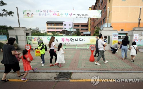 지난 11일 오전 경기 부천의 한 초등학교에서 학생들이 부모들과 함께 등교하고 있다. [연합뉴스 자료사진. 재판매 및 DB 금지]