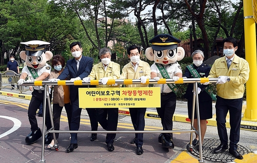 어린이보호구역 차량통행제한(의정부=연합뉴스) 안병용(오른쪽 4번째) 경기 의정부시장과 김계조(왼쪽 4번째) 행정안전부 재난안전관리본부장 등이 17일 청룡초교 정문 앞 도로를 막고 있다. 2020.6.17 [의정부시 제공. 재판매 및 DB 금지]