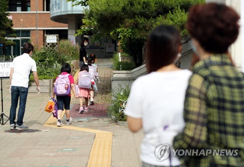 지난 11일 경기도의 한 초등학교에서 학부모들이 처음 입학한 자녀들의 등교를 지켜보고 있다. [연합뉴스 자료사진]