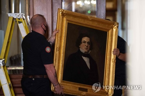 미국 의사당에서 철거되는 남부연합 하원의장 초상화(워싱턴 AFP=연합뉴스) 미국 의사당의 건물 유지보존업무를 맡은 의사당영선국(AOC) 직원들이 18일(현지시간) 워싱턴DC 의사당의 '하원의장 로비'에 걸려 있던 호웰 콥 전 남부연합 하원의장의 초상화를 떼고 있다. 낸시 펠로시 하원의장은 앞서 기괴한 인종차별의 상징이라며 콥을 비롯해 로버트 헌터, 제임스 오르, 찰스 크리스프 등 4명의 남부연합 하원의장의 초상화를 치울 것을 지시했다. sungok@yna.co.kr