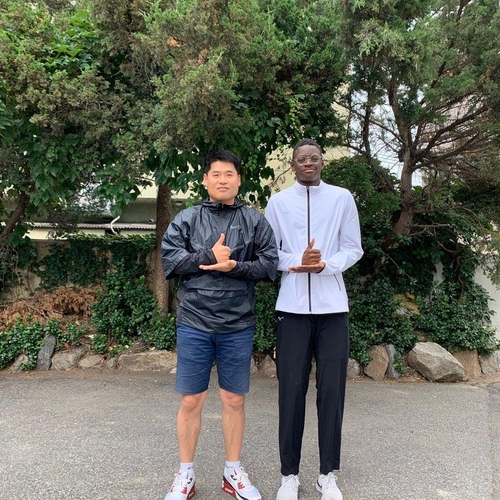 비웨사와 김동훤 지도자(서울=연합뉴스) 한국 육상 유망주 비웨사 다니엘 가사마(오른쪽)와 김동훤 원곡고 육상 지도자가 '덕분에' 세리머니를 하고 있다. [김동훤 원곡고 육상 지도자 제공. 재배포 및 DB금지]