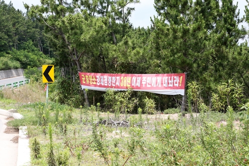 "군 휴양소 주민에게 돌려줘"(포항=연합뉴스) 손대성 기자 = 7일 경북 포항시 북구 송라면 화진리 해변 화진훈련장 주변에 주민이 붙여 놓은 현수막이 있다. 2020.7.8