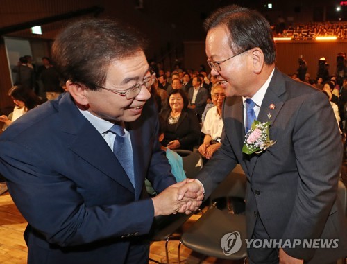 제31주년 6·10 민주항쟁 기념일이었던 2018년 6월 10일 서울시청 다목적홀에서 '민주에서 평화로'를 주제로 열린 기념식에서 당시 김부겸 행정안전부 장관(오른쪽)과 더불어민주당 박원순 서울시장 후보가 인사를 하고 있다.[연합뉴스 자료사진]