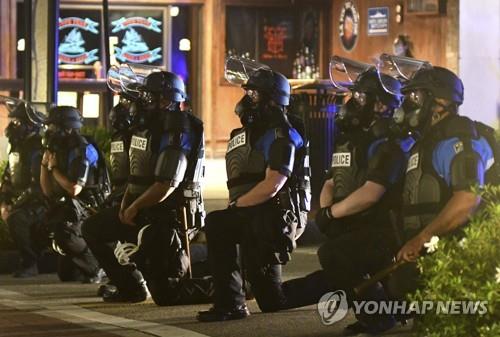 한쪽 무릎꿇고 연대 표시하는 미국 경찰 [AP=연합뉴스 자료사진]