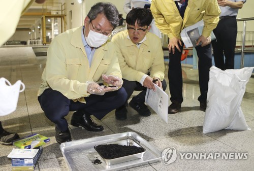 변성완 부산시장대행, 입상 활성탄 점검(부산=연합뉴스) 강덕철 기자 = 변성완 부산시장 권한대행이 21일 오후 경남 김해시 대동면 덕산정수장에서 채취한 입상 활성탄을 살펴보고 있다. 2020.7.21 kangdcc@yna.co.kr