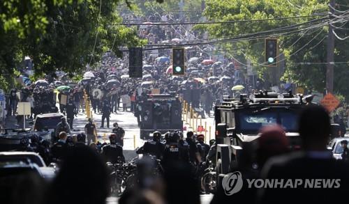 25일(현지시간) 시애틀의 한 경찰서 앞에서 마주한 시위대와 경찰[AP=연합뉴스]