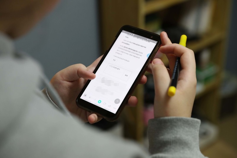 ②시험지를 받아온 조양이 집에서 스마트폰으로 출석 확인을 하고 있다. 박종식 기자